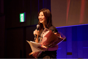 表彰式で花束を受け取る社員