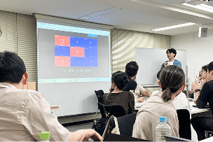 会議室でプレゼンを見る社員たち